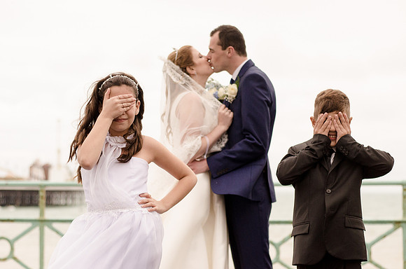 Bride and Groom near the Palace Pier, Brighton, Sussex embarrassing the young ones